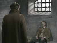 Doctor Martel (Bernard Horsfall) visits Peter Porteous (Richard Heffer) in his cell.