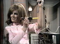 Angie (Geraldine Moffatt) demonstrates the Bag's 'foolproof' surgical knife on herself.