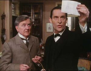 Hilton Cubitt (Tenniel Evans) and Holmes (Jeremy Brett) examine Cubitt's transcription of the dancing men pictograms.